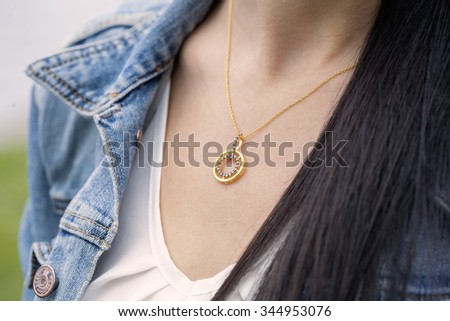 golden pendant in woman's decollete Royalty-Free Stock Photo #344953076
