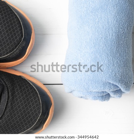 running shoes and towel on white wood table