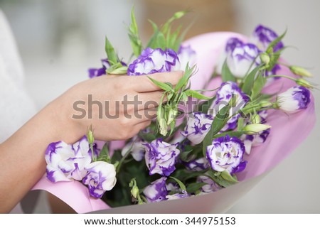 woman's hand holding a bouquet of flowers