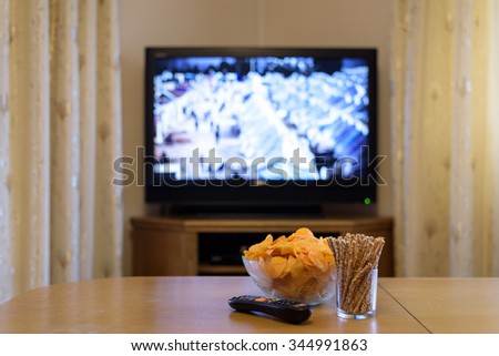 TV, television watching (refugee camp, news) with beer lying on the table - stock photo