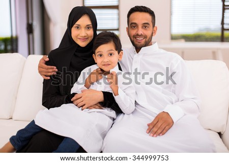 happy muslim family sitting on the couch at home Royalty-Free Stock Photo #344999753
