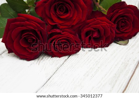 Beautiful red roses on a white wooden background