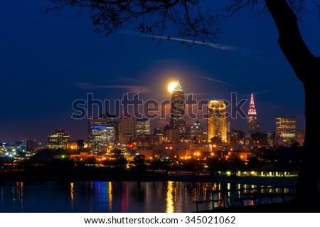 The full moon of November rises over Cleveland Ohio with reflections in Lake Erie