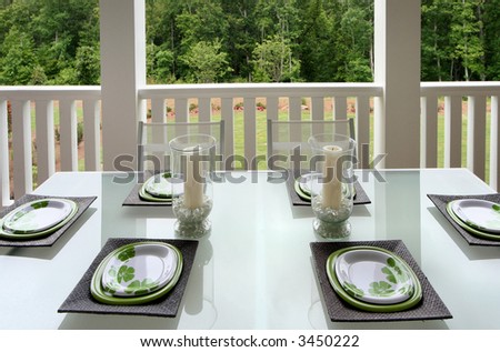 A casually sophisticated dining area on a patio porch of a home.