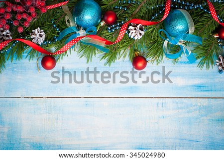 Winter christmas background with fir branches and decorations at blue wooden background