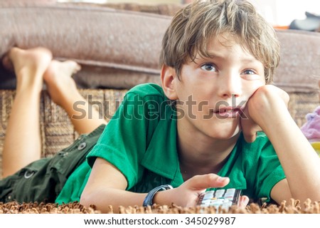 indoor portrait of young boy watching tv at home