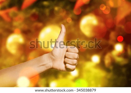 Woman hand making sign good. Woman hand with thumb up Isolated against Christmas or New Year tree. 