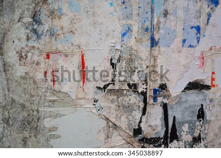 Colorful torn posters on grunge old walls as creative and abstract background