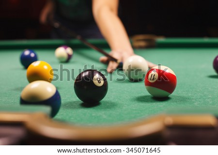 Playing billiard - Close-up shot of a man playing billiard Royalty-Free Stock Photo #345071645