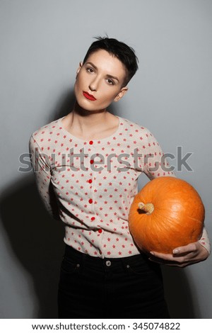 The short-haired brunette with the sweater with the stars holding a pumpkin.