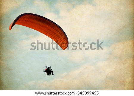 paramotor over sky with clouds, vintage paper art texture - retro style