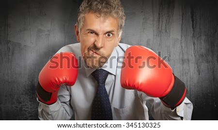 Businessman in red boxing gloves on background