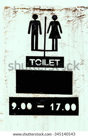 Restroom sign on cement wall