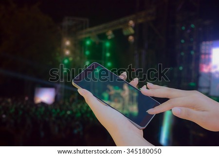 woman hands using mobile phone at concert 