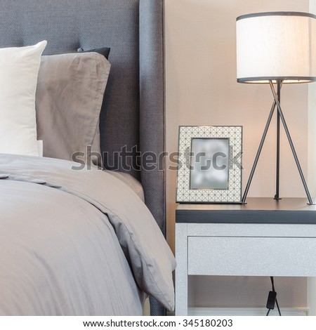 picture frame with lamp on table side in modern bedroom