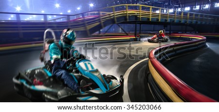 Two karting racers are racing on the grand track motion Royalty-Free Stock Photo #345203066