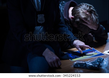 Police officer is pointing at the picture of victim