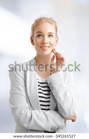 Close-up portrait of thinking businesswoman looking up while standing at workplace.