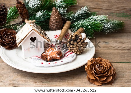 Christmas table setting with decorative birdhouse utensils and gingerbread cookies