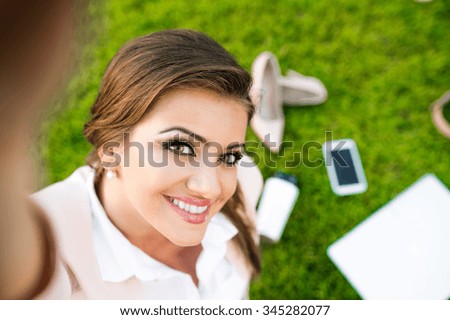 Beautiful young business woman sitting in a park
