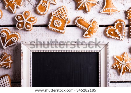 Christmas composition with gingerbreads and picture frame. Studio shot on white wooden background.