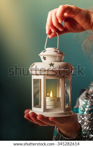 Christmas candlestick with burning candles in the hands of a child