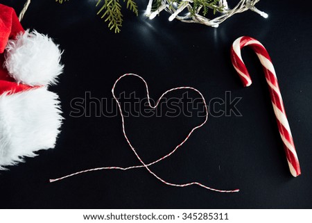 amazing beautiful green cedar and christmas silver garland and candy and santa hat on black background