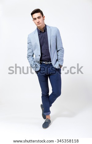 Stylish young man posing on a white background Royalty-Free Stock Photo #345358118