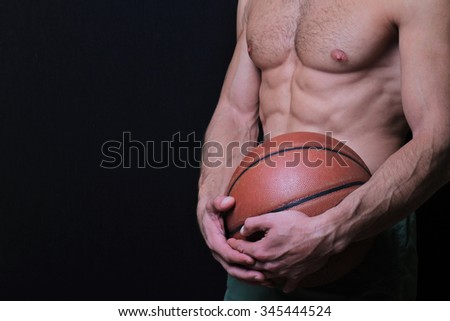 Close up of muscular man holding a basketball. Sport, active lifestyle concept