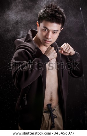 Portrait of Asian young man on black background - Fitness healthy guy and fighter concpet