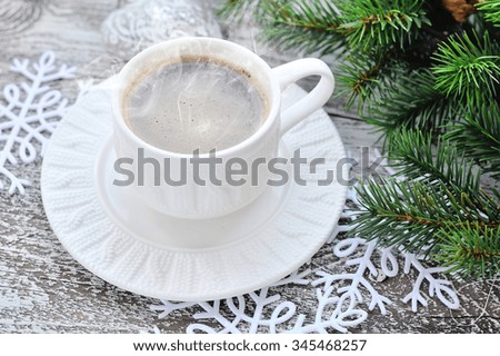 Cups of coffee and fir branches with christmas decorations on wooden table background