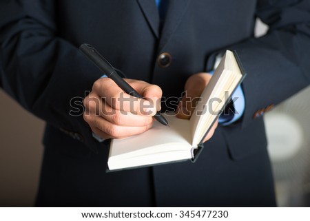 Hand writes in a notebook. advertising or business concept, isolated on a gray background.