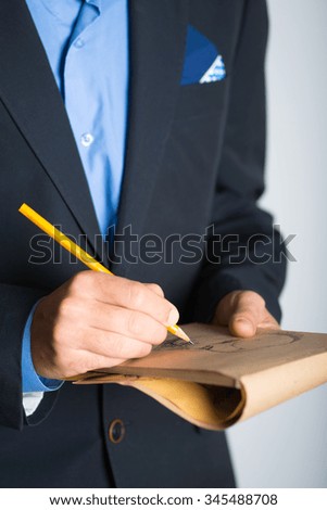 human hands painted with a pencil in a notebook. advertising or business concept, isolated on a gray background.