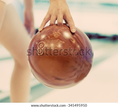 Woman's hand throwing ball in bowling club.