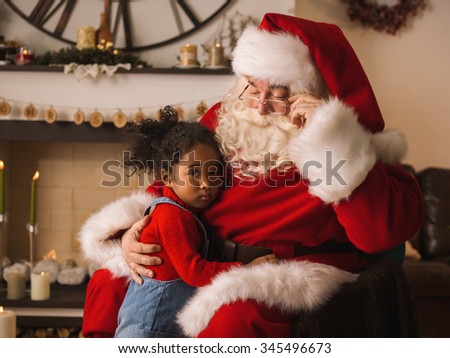 Santa Claus hugging with cute african american Child at Home