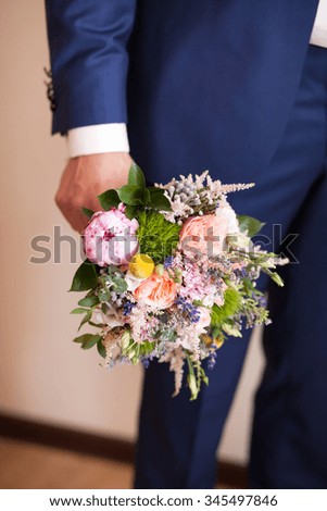 Groom with a bouquet . Groom in a classic costume