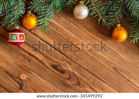 Christmas tree branch and toys Christmas balls on a wooden background