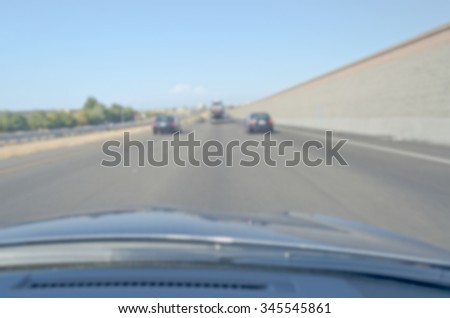 Defocused background of a highway seen from inside a car. Intentionally blurred post production for bokeh effect