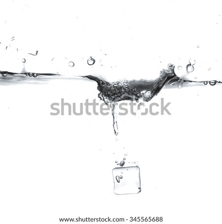 Ice cube is dropped into clear water isolated on white background