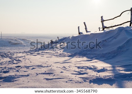Winter landscape with wooden fence