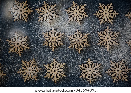 Holiday design wooden snowflakes in snow on dark blue navy background