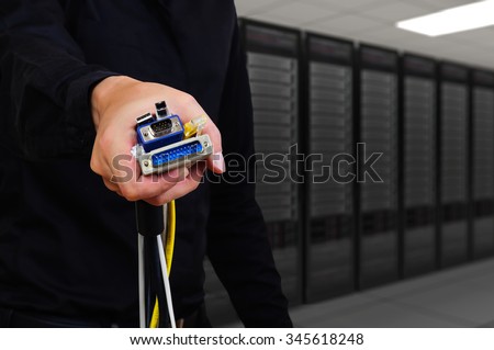 male holding several type of connector wire with sever room background
