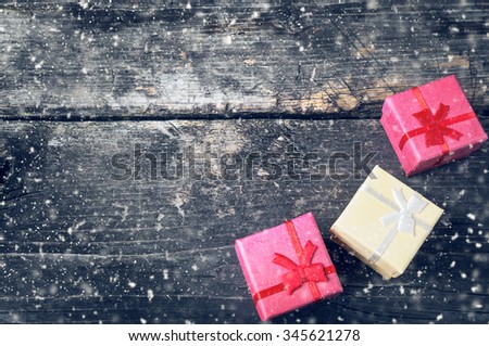 Boxes for gifts on old boards. Christmas background. Christmas decorations. New Year background. Xmax background. Holiday background. Toned image. Falling Snow .