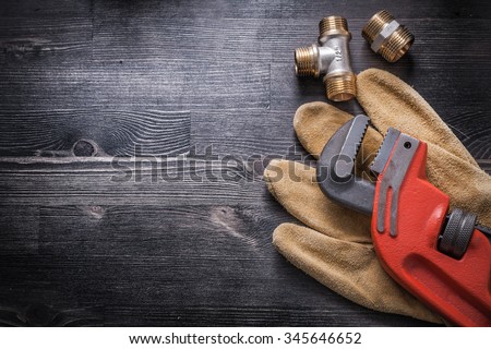 Monkey wrench brass plumbing fittings leather safety gloves construction concept. Royalty-Free Stock Photo #345646652