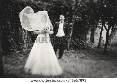 Wind play with veil of bride background groom
