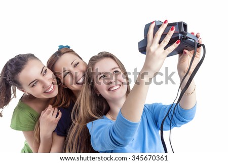 Youth Lifestyle Concept and Ideas. Three Young Positive Smilnig Caucasian Ladies Making Self Photographs With Photocamera. Isolated Over White Background. Horizontal Image Orientation
