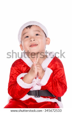 A little asian boy with a santa cap wishing something. Beautiful baby making a wish with Christmas gift box. Isolated on white background