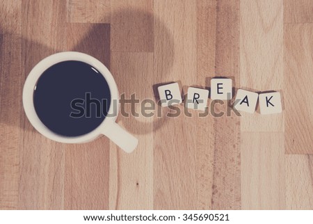 Coffee break. An image of a coffee cup filled with black coffee and a text next to it saying break made from plastic letters. Image has a coffee tone and vintage effect applied.