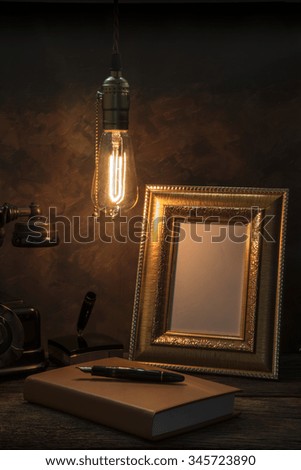 Still life of vintage telephone with picture frame and diary on table