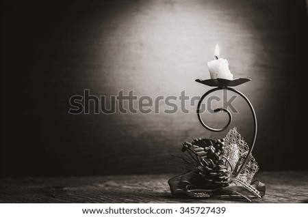 burning candle on a dark green background,black and white photo